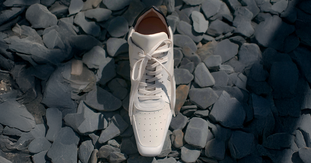 Sneaker heel blanca Sabinis sobre piedras grises bajo luz natural