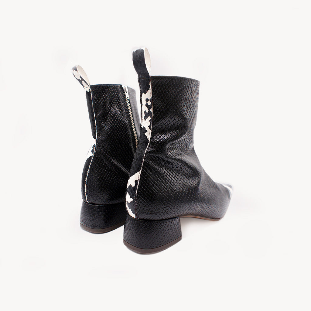 Botín de piel negra con grabado efecto pitón y puntera pitón blanco y negro — Sabinis, vista trasera y lateral