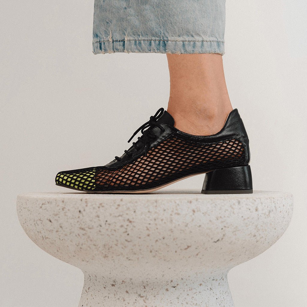 Zapato comodo mujer con tacon cuadrado, en piel negra con rejilla y puntera lima. Modelo London Black Lime de Sabinis.