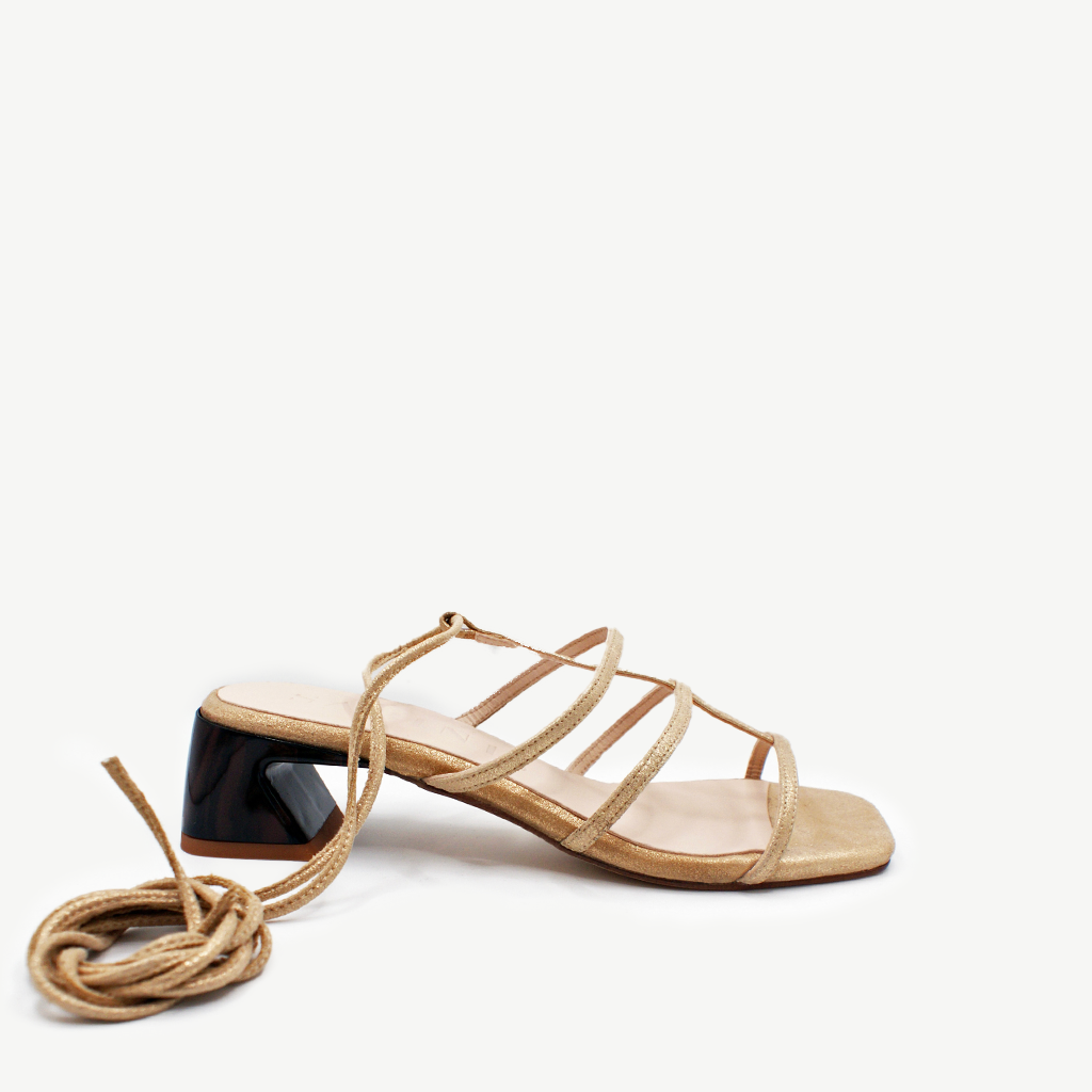 Sandalia Eternal dorada de Sabinis, en piel ante dorado metalizado con tiras y para atar al tobillo, vista lateral.
