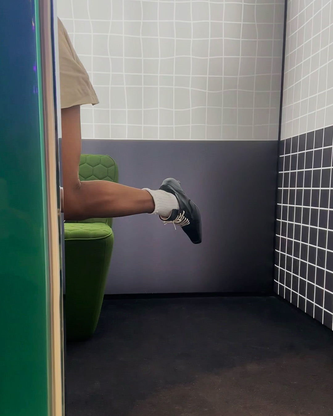 Zapato negro Sabinis para mujer en look casual moderno con calcetines blancos, en espacio probador